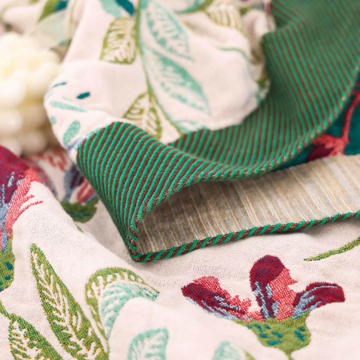 Close-up of the blanket's dark green striped band, oatmeal band and twisted green and brown edge stitch