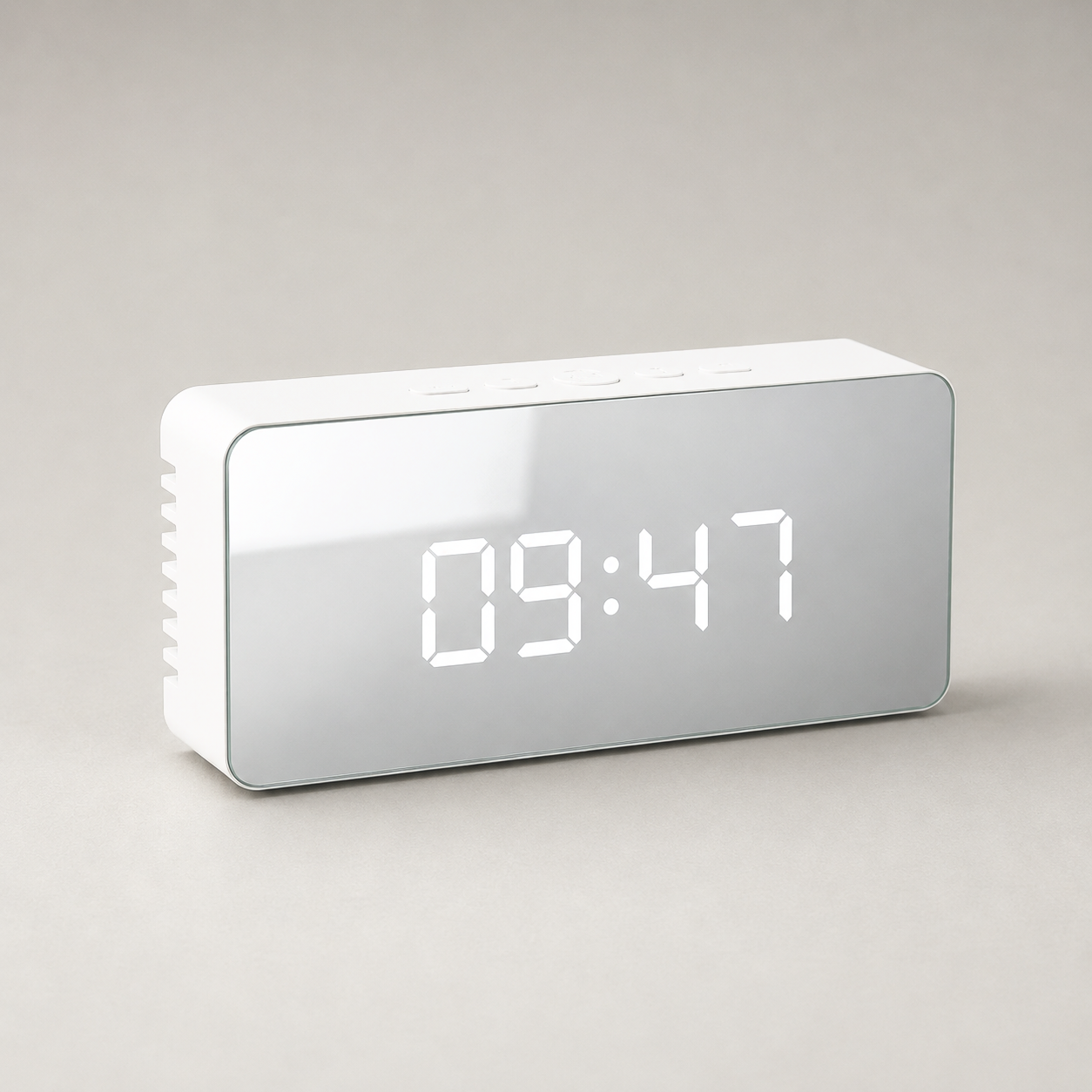 Studio photograph of the mirror alarm clock from the front, matte white body and mirrored face showing 09:47
