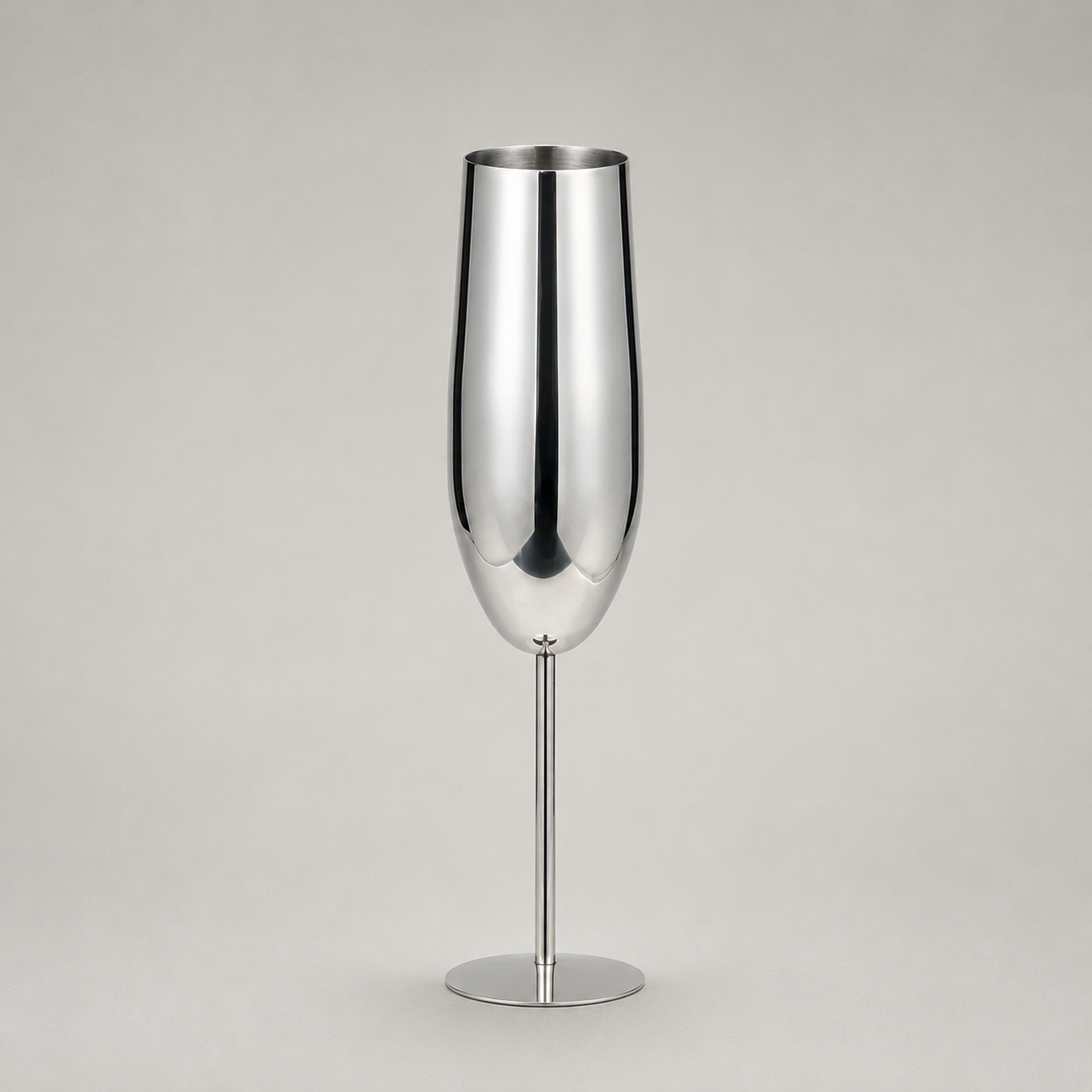 Single silver stainless steel champagne flute on a warm grey studio background
