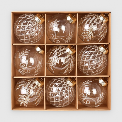 Box of 9 clear Christmas baubles with champagne glitter lattice, scroll and frond designs and gold caps