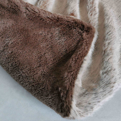 Corner of the taupe throw turned back to show its brown velvet underside
