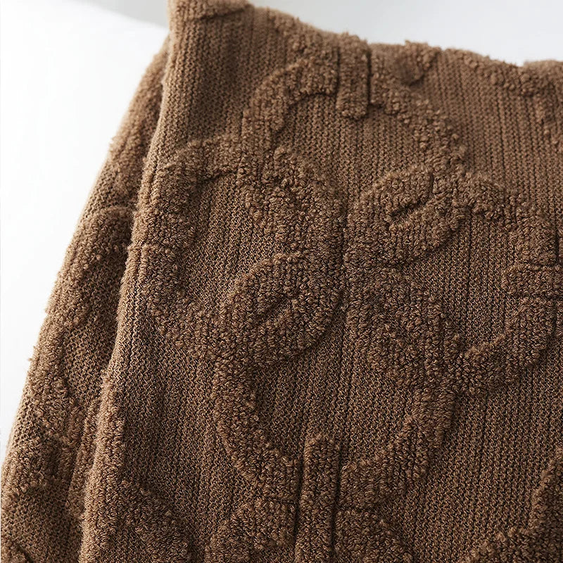 Close-up of the brown throw's raised looped rings on a fine ribbed knit