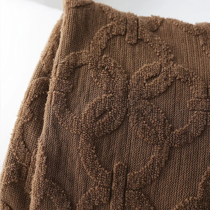 Close-up of the brown throw's raised looped rings on a fine ribbed knit