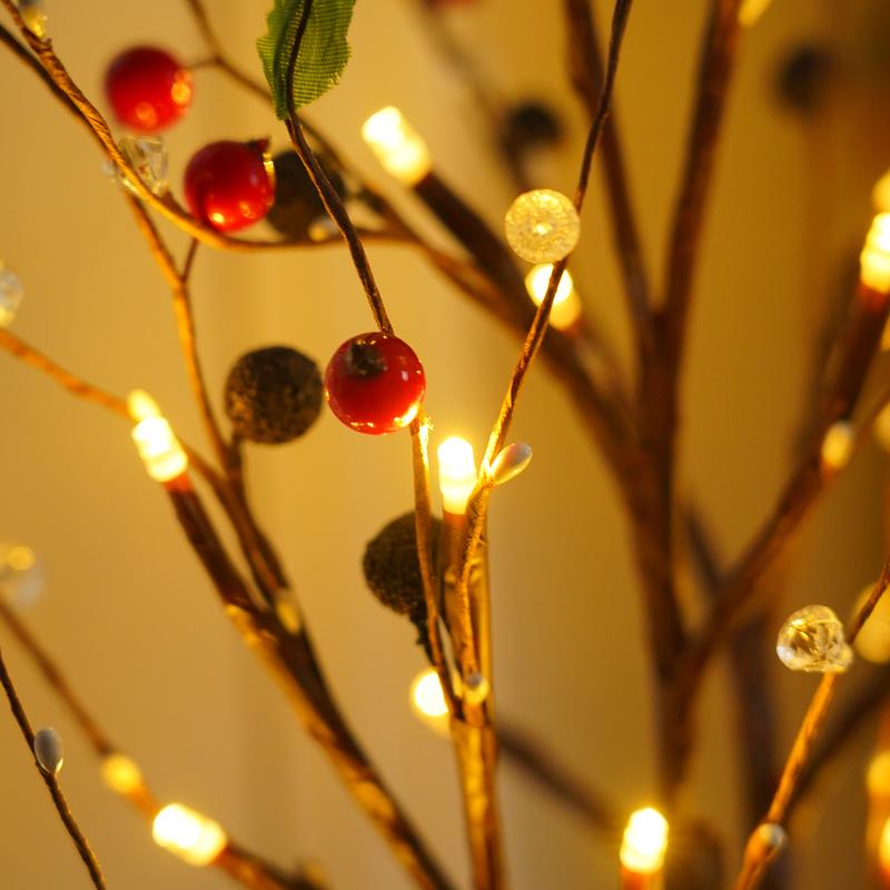 Close-up of the red berries, dark textured buds, clear faceted beads and tiny warm LED bulbs along the branches