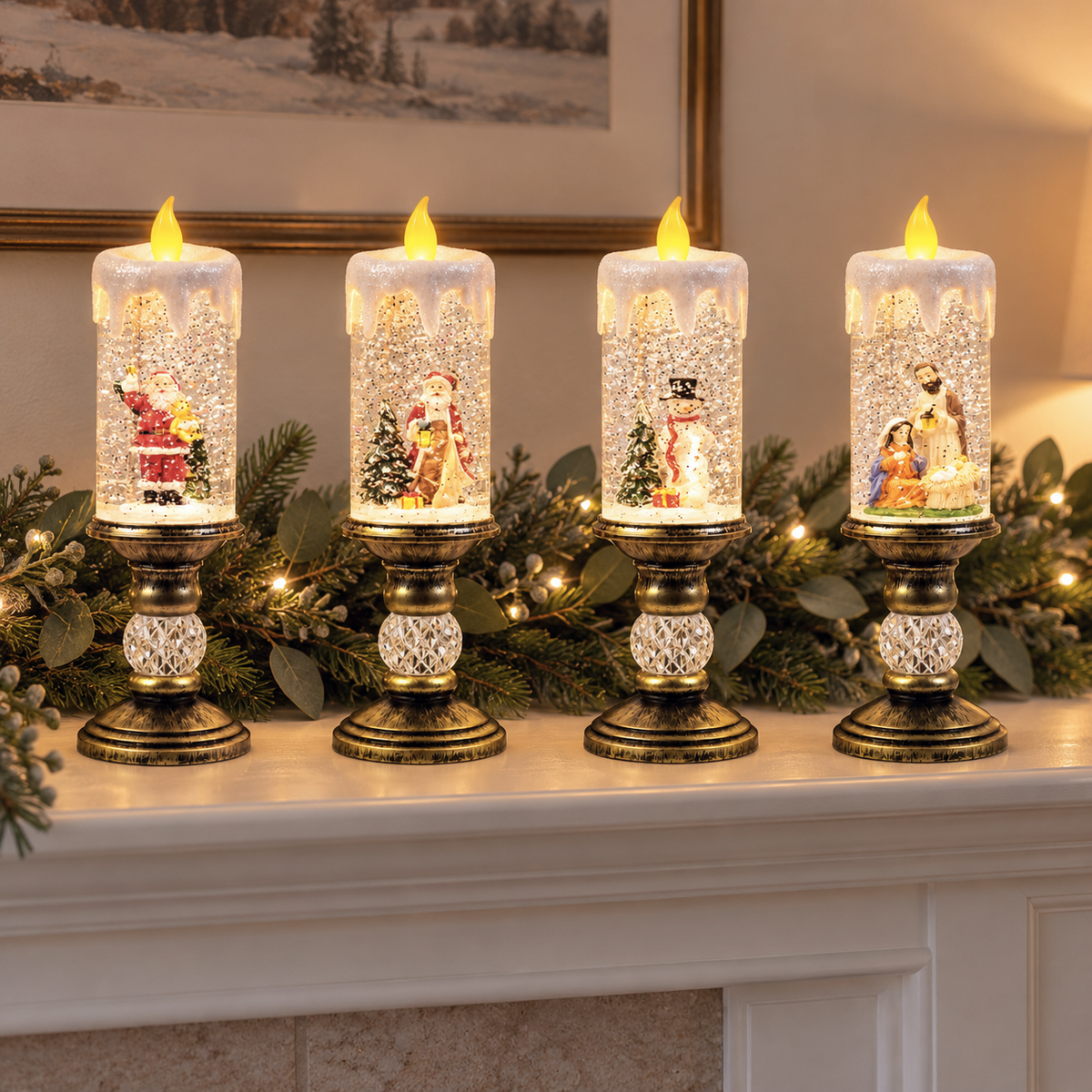 Four lit snow globe candles in a row on a white mantel with a pine garland and fairy lights: Santa with a teddy bear, Santa with a lantern, the snowman and the nativity scene