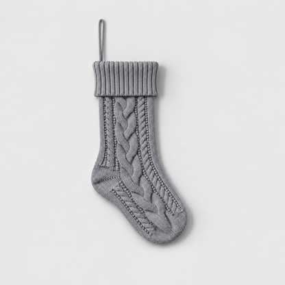 Gray cable knit Christmas stocking with a ribbed cuff on a light gray background