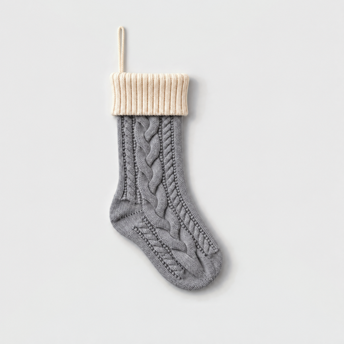 Gray cable knit Christmas stocking with a cream ribbed cuff and cream hanging loop
