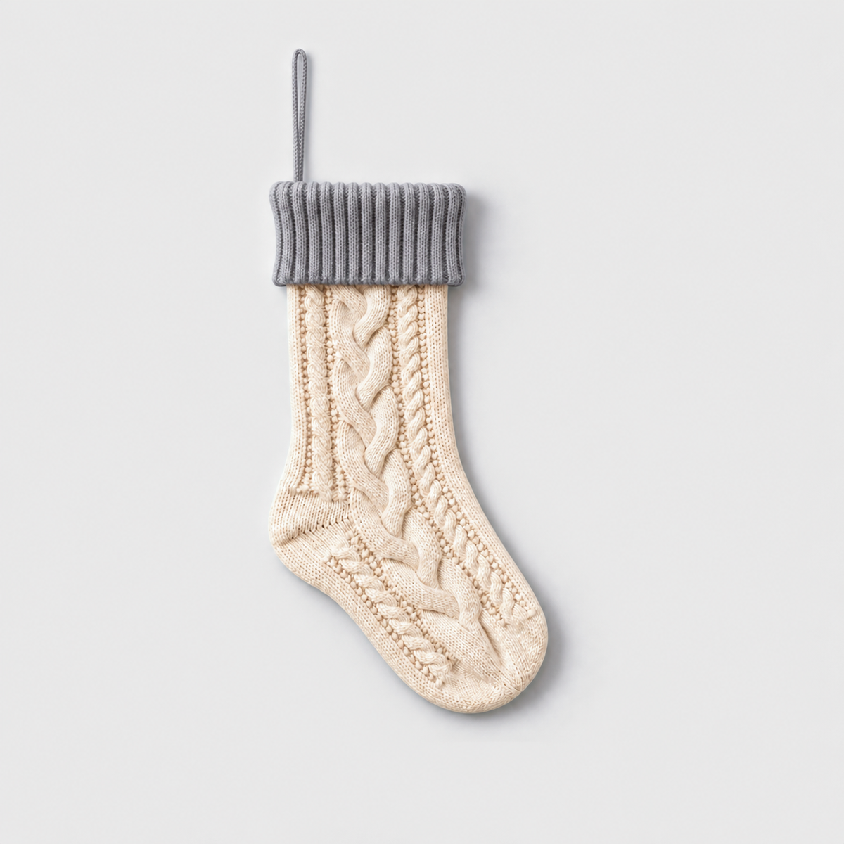 Cream cable knit Christmas stocking with a gray ribbed cuff and gray hanging loop
