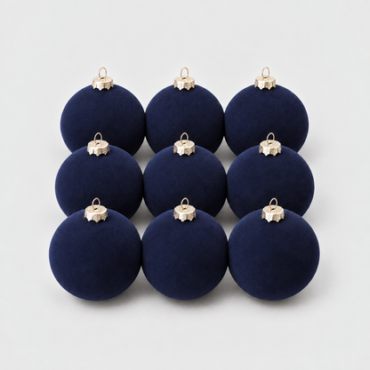 Nine navy velvet Christmas baubles grouped together on a light gray background