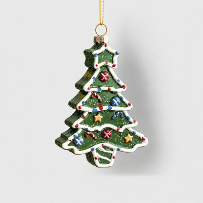 Green Christmas tree ornament with white icing piping, painted baubles and gold stars, hanging on a light gray background