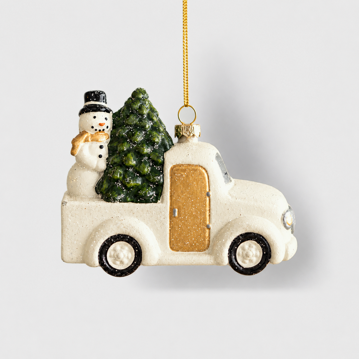 White pickup truck Christmas ornament with a gold door, a snowman and a fir tree in the back, on a light gray background