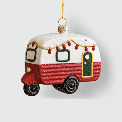 Red and white camper trailer Christmas ornament with tiny red string lights and green windows, on a light gray background
