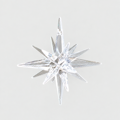 Clear faceted plastic star ornament on a plain light grey background