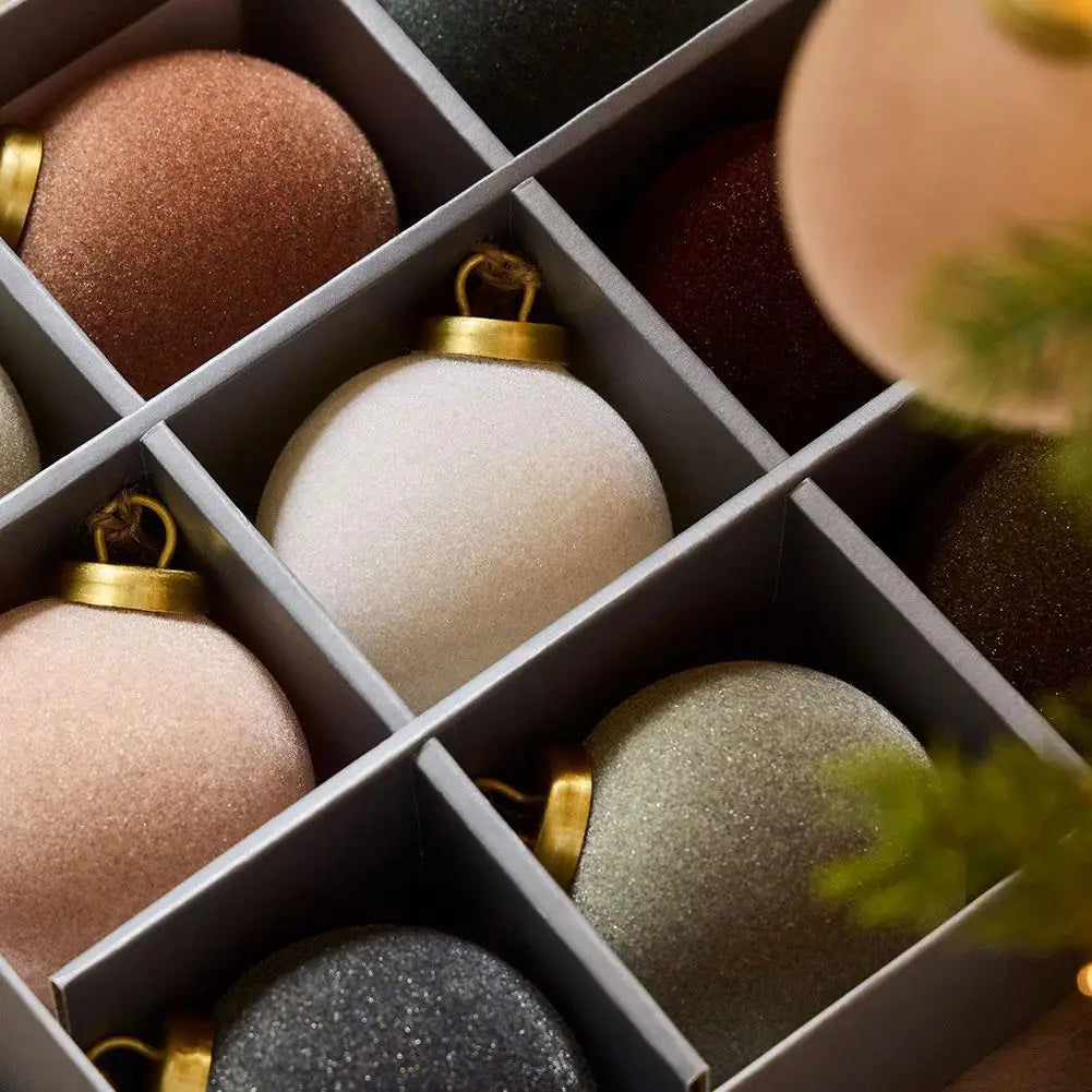 Close-up of velvet baubles sitting in the compartments of their box