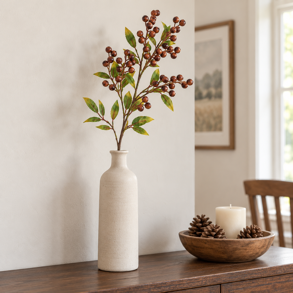 Single rust brown berry branch in a cream stoneware bottle vase on an oak sideboard