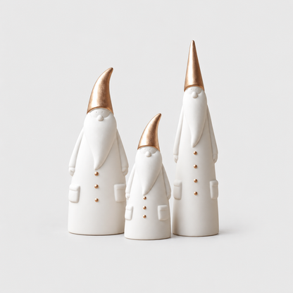 Set of three matte white ceramic Santa figurines in three heights with rose gold hats on a light gray background