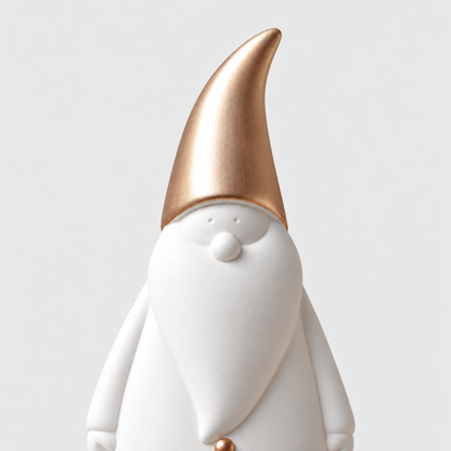 Close-up of the brushed rose gold hat, small dot eyes and round nose on a matte white ceramic Santa figurine