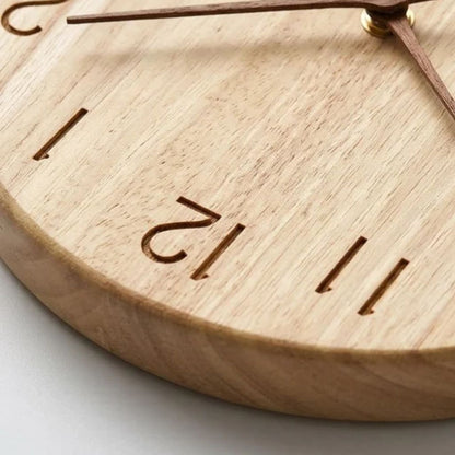 Close-up of the engraved numbers 11 and 12 cut into the rubberwood face, with the rounded edge of the clock