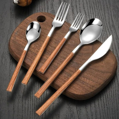 Silver cutlery set with wood-look handles: knife, fork, dessert fork, soup spoon and teaspoon on a walnut board