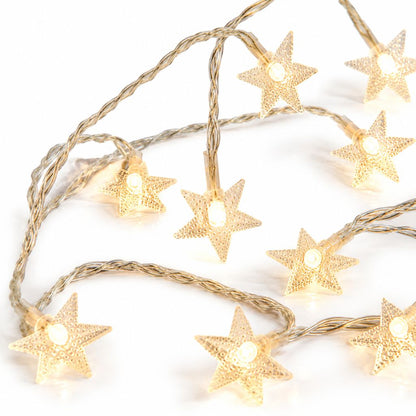 Warm white star fairy lights lying in loose loops on a white surface