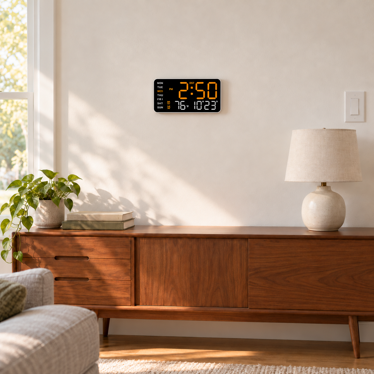 Digital wall clock with orange LED display hung above a walnut sideboard in a bright living room