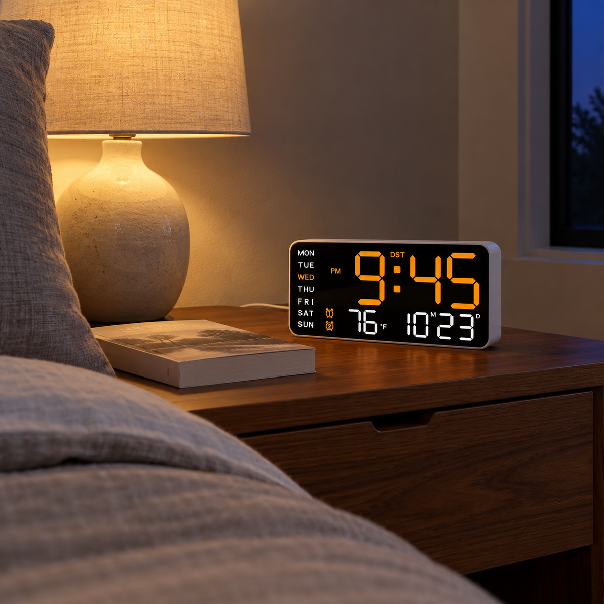 Digital alarm clock with dimmed orange display on a bedside table at night