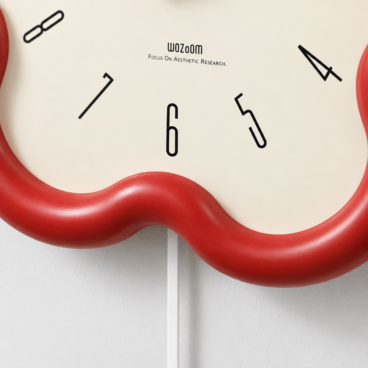 Close-up of the thick rounded red frame standing out from the cream dial at the bottom of the flower clock