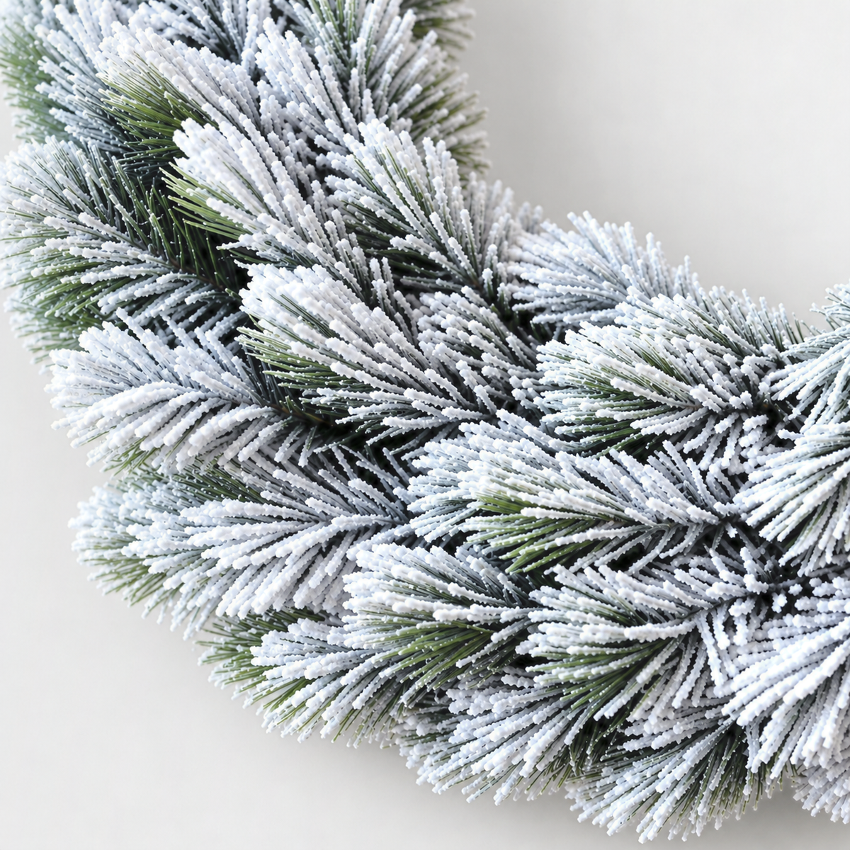 Close-up of the white frost on the wreath's pine needles with dark green showing underneath