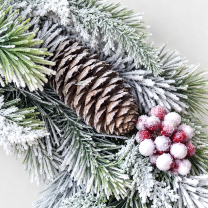 Close-up of a frosted pine cone and a cluster of frosted red and white berries on the wreath