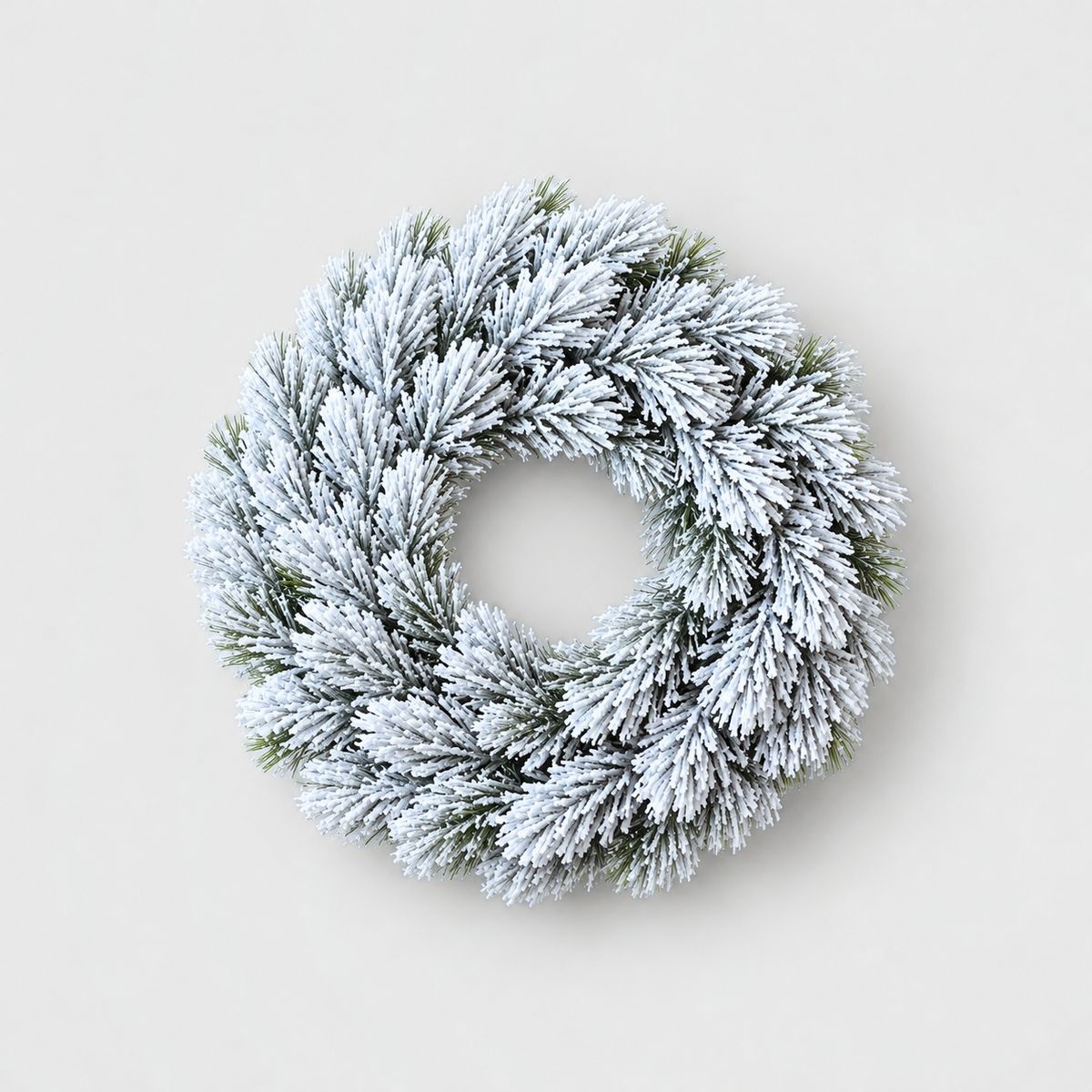 Small plain frosted pine Christmas wreath, 12 inches across, on a light grey background