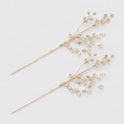 Two champagne gold bead branch picks with clear acrylic beads on a light gray background