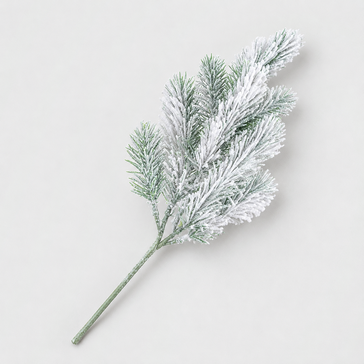 Frosted faux pine stem with white flocked needles on a light gray background