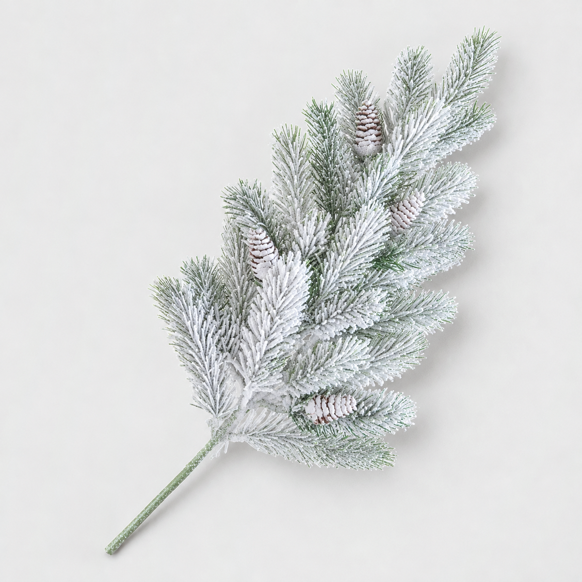 Large frosted faux pine stem with small frosted cones on a light gray background