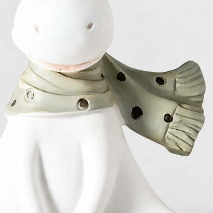 Close-up of the reindeer figurine's green-gray scarf with dark dots and a fringed end