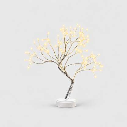 LED tree lamp with silver branches and warm white fairy lights, lit, on a white round base