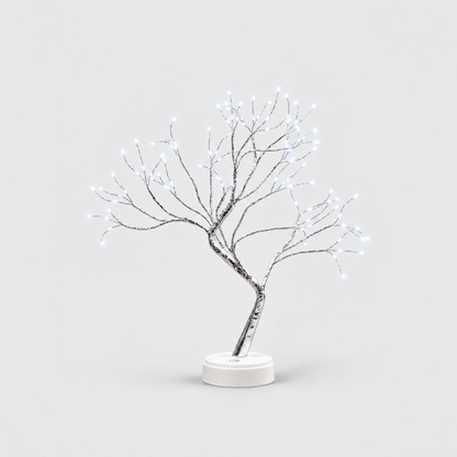 LED tree lamp with silver branches and cool white fairy lights, lit, on a white round base