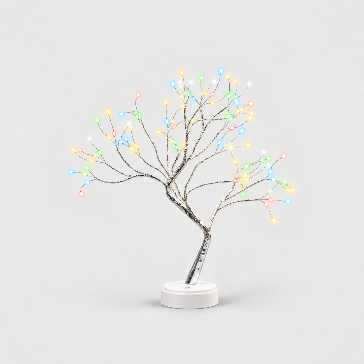 LED tree lamp with silver branches and multicolor fairy lights, lit, on a white round base