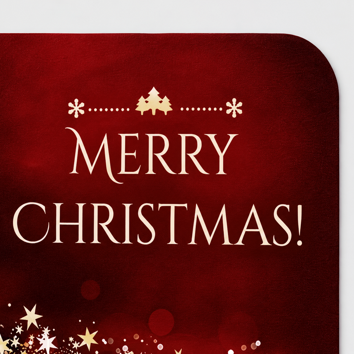 Close-up of the ivory Merry Christmas lettering, snowflakes and little fir trees printed on the red door mat