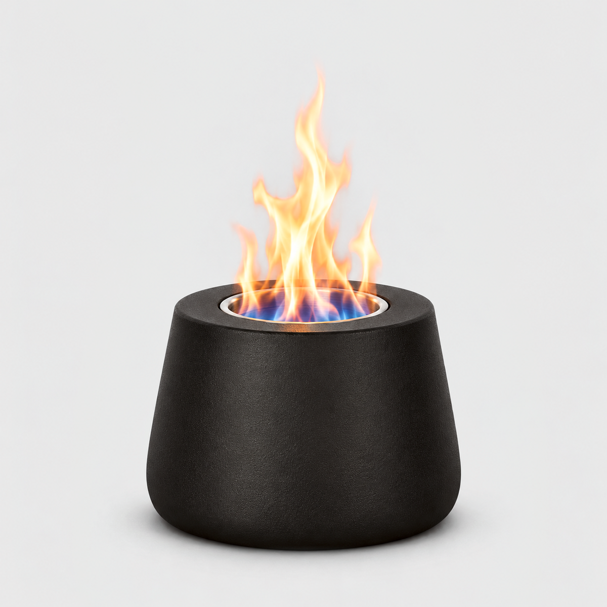 Black tabletop fire pit burning with a blue and orange flame from its stainless steel cup, on a light gray background
