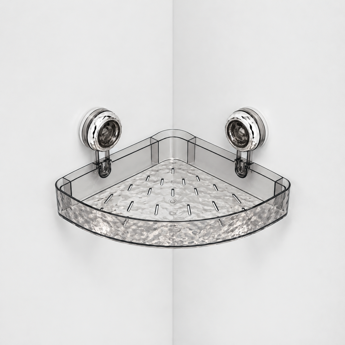 Gray see-through corner shower shelf with a rippled front and a slotted rippled floor, held in a light grey corner by two chrome suction cups