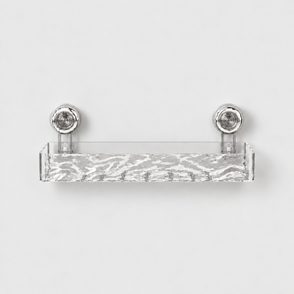 Clear long shower shelf with a rippled front and a row of drain slots in its floor, on two chrome suction cups