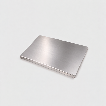 Large stainless steel chopping board on a light gray background, the lip folded down along its front edge