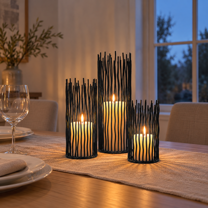 Three black iron candle holders in three heights with lit pillar candles as a dining table centerpiece
