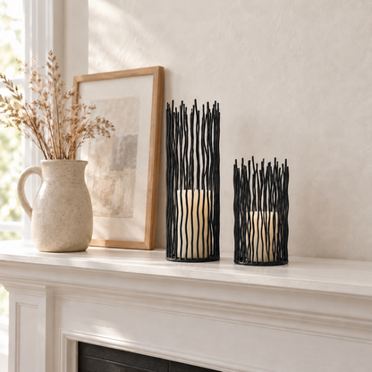 Small and Large black iron candle holders with ivory pillar candles on a white fireplace mantel in daylight