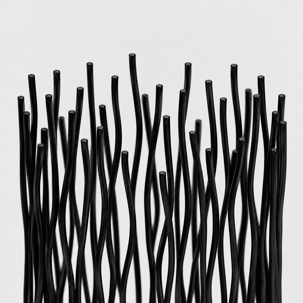 Close-up of the wavy black iron rods and their uneven tops on the candle holder