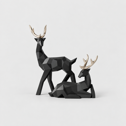 Pair of black geometric faceted reindeer sculptures with gold antlers, one standing and one lying down, on a light gray background