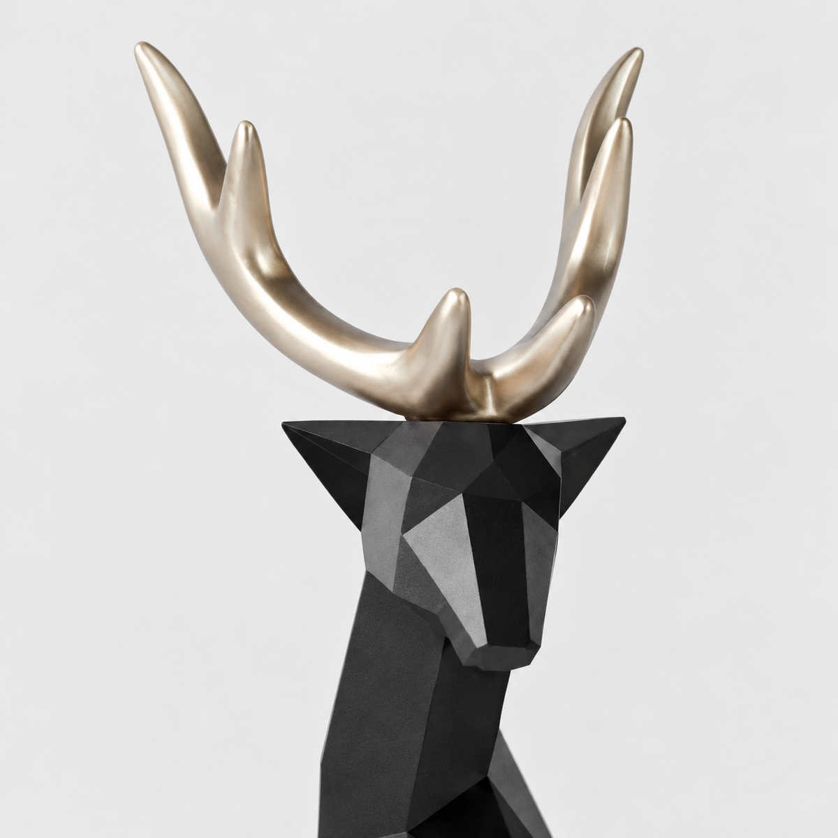 Close-up of the black faceted reindeer head with smooth champagne gold antlers