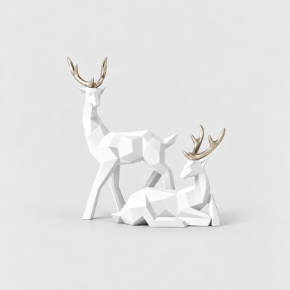 Pair of white geometric faceted reindeer sculptures with gold antlers on a light gray background