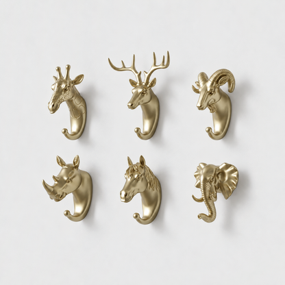 Six gold animal head wall hooks, giraffe, deer, ram, rhino, horse and elephant, on a plain light gray wall
