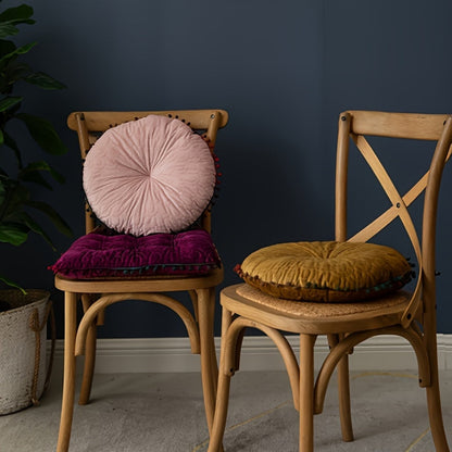 Pink round cushion on a bentwood chair back and a mustard cushion on a second chair seat
